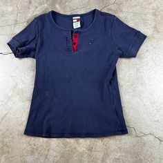 "Vintage Y2K navy blue shirt. Ribbed, three button front, and cropped cut. Good condition, minor wear. Brand: Tommy Jeans Size: Women's Large Measurements: 21\" long 18\" pit to pit" Casual Blue T-shirt With Buttons, Basic Short Sleeve Tops With Buttons, Blue Cotton Tops With Snap Buttons, Blue T-shirt With Button Closure And Crew Neck, Blue Short Sleeve T-shirt With Buttons, Blue Short Sleeve Tops With Snap Buttons, Blue Short Sleeve Top With Snap Buttons, Blue Crew Neck T-shirt With Buttons, Navy Casual Tops With Snap Buttons