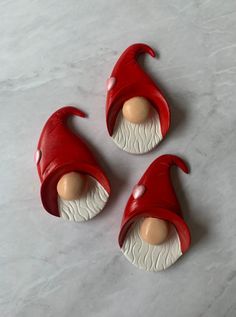 three red and white gnome's hats sitting on top of a table