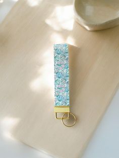 a blue and white flowered paper clip sitting on top of a wooden table