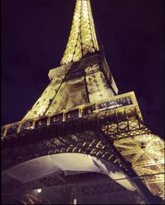 the eiffel tower is lit up at night