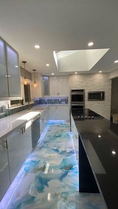 a modern kitchen with blue water running down the counter tops and floor to ceiling windows