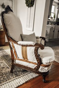 an old fashioned chair sitting on top of a hard wood floor next to a rug