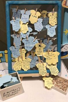 a bulletin board with clothes pins and notes attached to it, sitting on a table