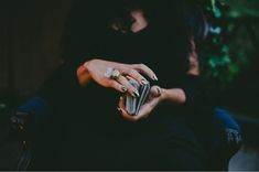 a woman is holding her cell phone while sitting down