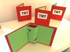 three red and green folders sitting on top of a white table next to each other