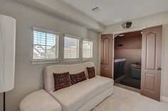 a living room with a couch, chair and closet in the back ground floor area