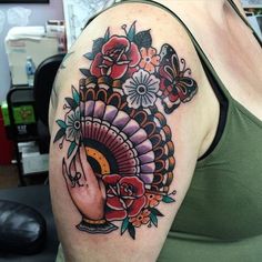 a woman with a tattoo on her arm has a turkey and roses in the center