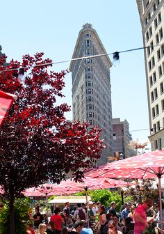 many people are sitting under umbrellas in the city