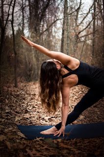 a woman is doing yoga in the woods