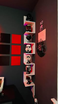 a room with red and black walls and shelves on the wall are star wars themed items