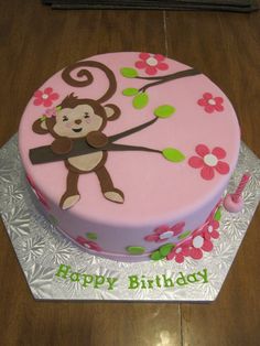 a pink birthday cake with a monkey on it