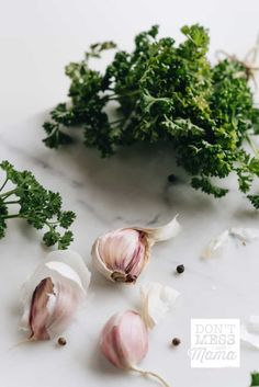 garlic and parsley on a white counter top