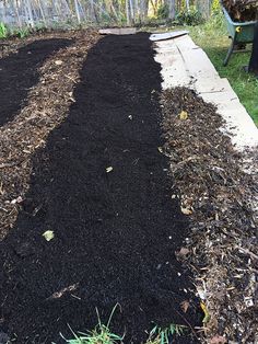 the garden is full of black mulch and dirt