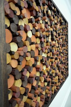 an art piece made out of wood with circles and dots on the wall behind it