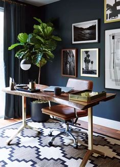 a home office with blue walls and pictures on the wall, including a potted plant