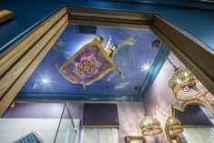 the ceiling is decorated with art and decorative items in gold, purple, and blue