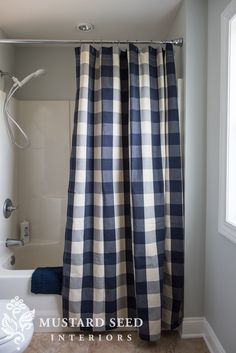 a bathroom with a checkered shower curtain next to a toilet and bathtub in it