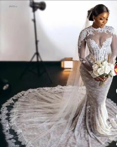 a woman in a wedding dress is posing for the camera with flowers on her bouquet