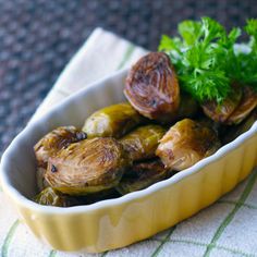 a dish filled with brussel sprouts on top of a white towel