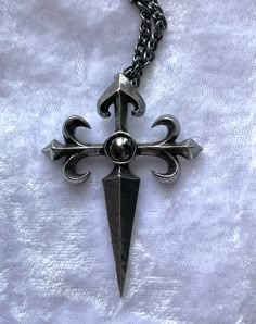 The charge of the 12th century Spanish knights, The Order of St. James of the Sword, vowed to protect pilgrims and extirpate infidels. An antiqued pewter cross pendant in a traditional style, raised in relief with fleur-de-lys ends to the arms of the cross and a sword-pointed shaft, and a dark, round hematite cabochon at its centre. The pendant comes with a velvet gift pouch. Made by Kiss of a red rose with help from Alchemy England 1977. Metal Casting Jewelry, Skull Necklaces, Silver Jewelry Aesthetic, Weird Videos, Stack Jewelry, Wedding Jewelry Silver, Jewelry Grunge, Ethereal Jewelry, Jewelry Stack