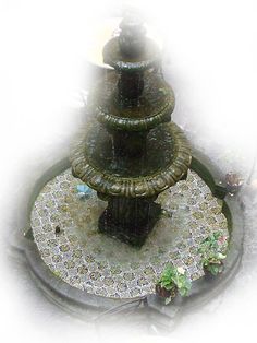 a three tiered fountain in the middle of a garden