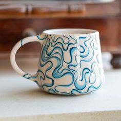 a blue and white coffee cup sitting on top of a counter