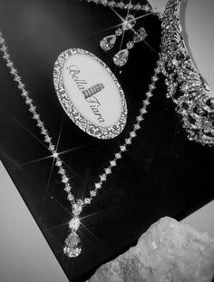 a black and white photo of a tiara, necklaces and earrings on display