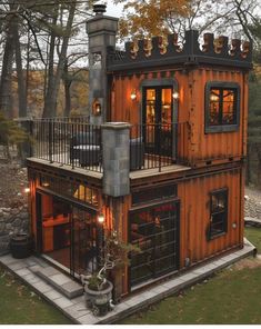 a house made out of shipping containers with lights on the windows and balconies