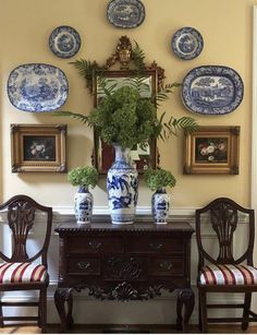 two chairs and a table with blue and white plates on the wall