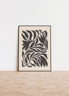 a black and white art print on a wall in an empty room with wood flooring