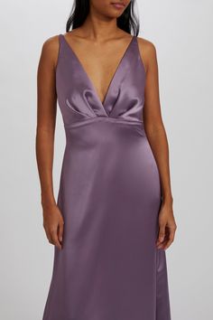 a woman wearing a purple dress with a deep v - neck