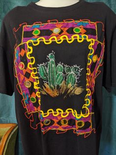 a black t - shirt with an image of a cactus on it