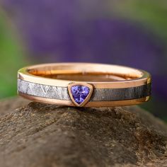 a gold and silver ring with a heart shaped tanzante stone in the center