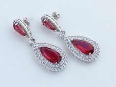 Absolutely stunning!! Ruby red cubic zirconia large teardrop bridal earrings in rhodium plated brass setting. Earrings feature a large teardrop with pear cut red ruby cubic zirconia center surrounded by two rows of clear zirconia crystals. Teardrop dangles from a red ruby cubic zirconia teardrop ear stud. Total length of the earrings is 5.5 cms. To browse my collection click : https://www.etsy.com/your/shops/fantasycrystals Red Teardrop Dangle Earrings For Formal Occasions, Elegant Red Drop Crystal Earrings, Red Dangle Teardrop Earrings For Formal Occasions, Red Drop Bridal Earrings For Formal Occasions, Red Drop Earrings For Formal Occasions, Red Teardrop Earrings For Formal Occasions, Red Pear-shaped Earrings For Formal Occasions, Formal Red Pear-shaped Earrings, Red Ruby Drop Earrings