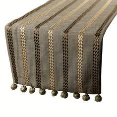 a striped tablecloth with pom poms on it's sides and two different colors