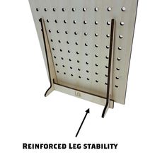 a metal pegboard with holes on it and an arrow pointing to the left side