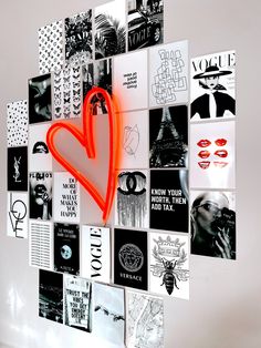 a heart shaped neon sign is hanging on the wall next to many different types of posters