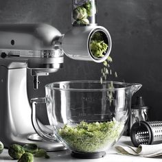 a blender filled with green vegetables on top of a counter next to other ingredients