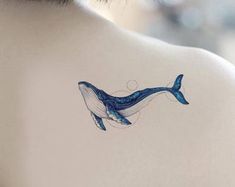 a blue whale tattoo on the back of a woman's neck