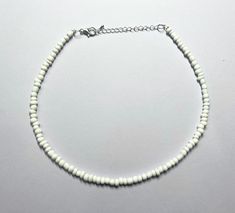 This beautiful necklace is handmade with large white seed beads. It comes in multiple different sizes (14, 16, 18, 20, 22, and 24 inches), ranging from a choker fit to a longer necklace. Every necklace from my shop also comes with additional extender chain, making it easily adjustable. Message with any questions or personalization requests! White Beaded Chain Choker Jewelry, Adjustable White Beaded Chain, White Beaded Chain Bracelets For Summer, White Letter Beads Choker Necklace, White Tiny Beads Choker For Beach, White Choker Jewelry With Colorful Beads, White Beaded Chain Choker As A Gift, White Round Beaded Necklaces For Festival, White Round Beads Choker For Beach