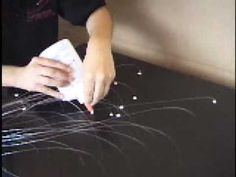 a person wiping down something on top of a black table with white lines and dots