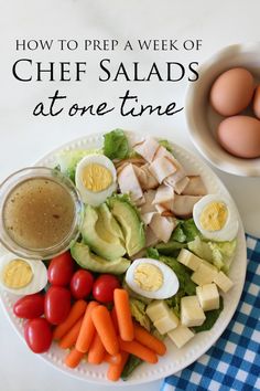 a white plate topped with salad and eggs next to a bowl of dressing on top of a blue checkered table cloth