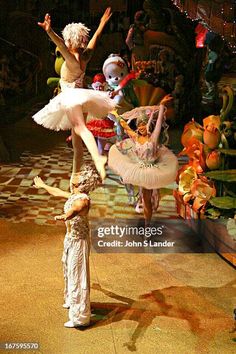 two ballerinas are performing on stage with their arms in the air and one is balancing