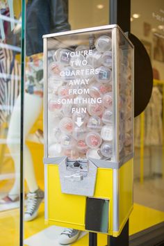 a gummy machine sitting in front of a store window