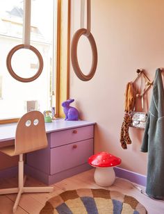 a child's room with pink walls and purple furniture, including a toy mushroom