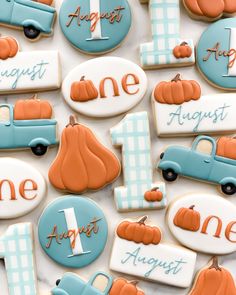 decorated cookies are arranged in the shape of cars and pumpkins for first birthday party