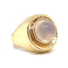 Magical moonstone! This romantic and chic Mid-Century ring features a round moonstone. The cabochon cut moonstone has a soft, icy pink hue and is set on a radiant 14 karat yellow gold band. The bezel features an earthy texture. The perfect accessory for both daytime and nighttime attire. Sleek enchanting in design. Yellow Gold Moonstone Ring For Formal Occasions, Yellow Gold Polished Moonstone Ring, Gold Moonstone Cabochon Ring, Modern Yellow Gold Round Moonstone Ring, Formal Moonstone Cabochon Ring, Modern 14k Gold Round Moonstone Ring, Formal Round Moonstone Ring In 14k Gold, 14k Gold Round Moonstone Formal Ring, Formal 14k Gold Round Moonstone Ring