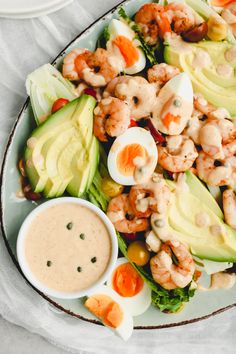 a salad with shrimp, avocado and dressing