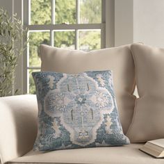 a blue and white pillow sitting on top of a couch