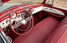 the interior of a classic car with red leather